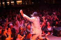 a man in a suit performs on stage in front of a crowd